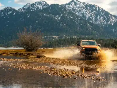Jeepsafari in het Taurusgebergte Oranje jeep rijdt door een waterplas tijdens een avontuurlijke offroad jeepsafari in het Taurusgebergte, Antalya, Turkije.