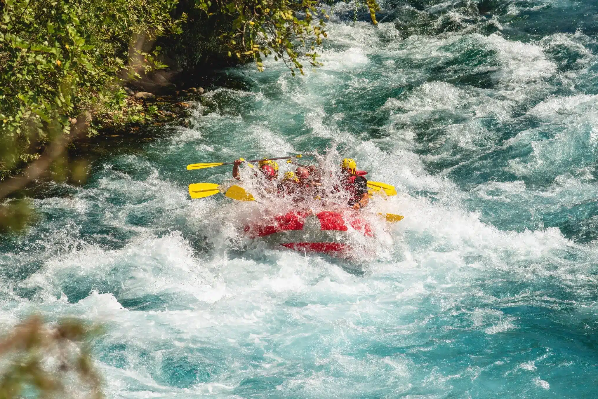 Een groep mensen in een rode raft die door het kolkende water van Köprülü Canyon in Antalya, Turkije, vaart.